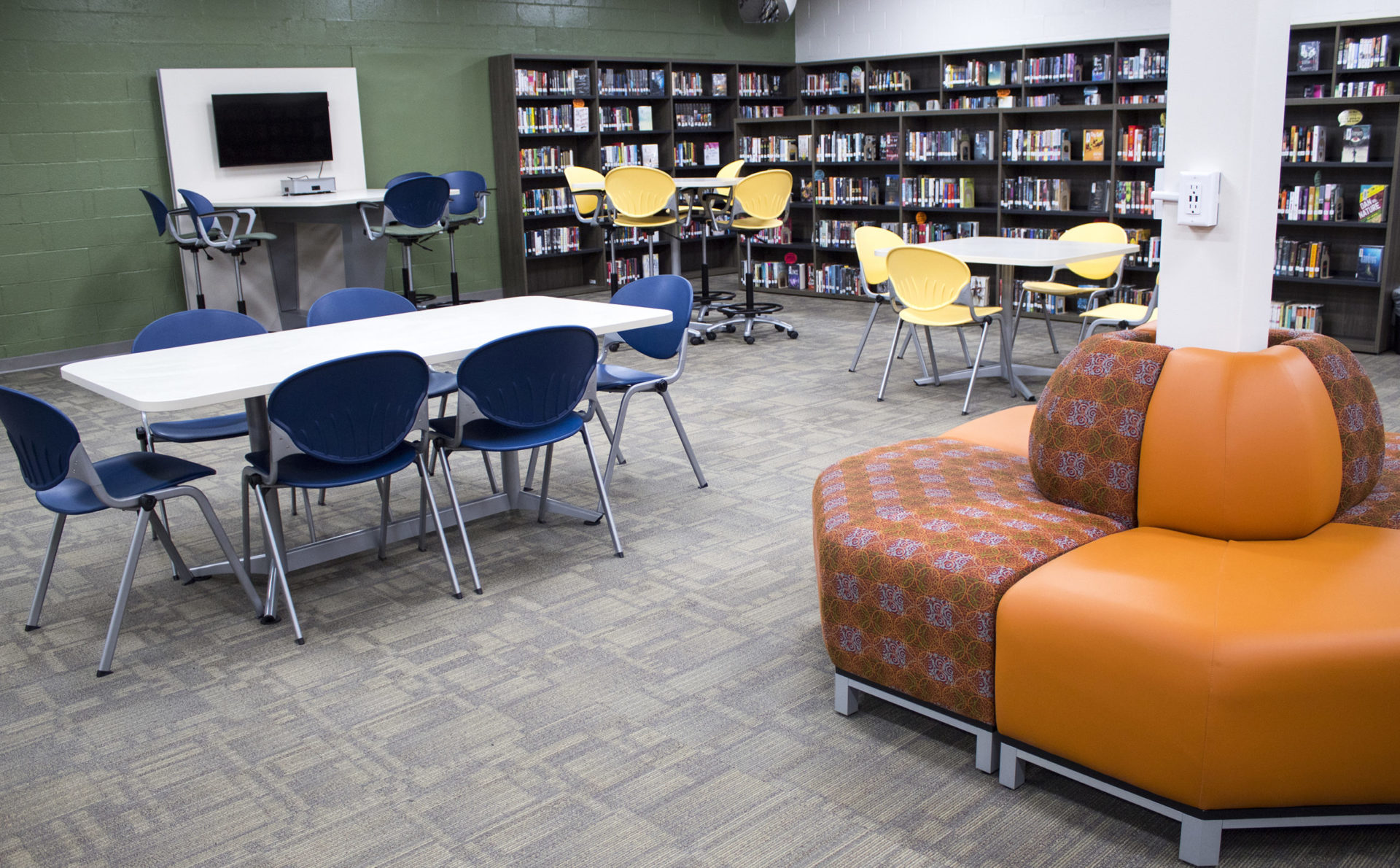 student library with tables chairs lounge seating and bookshelves
