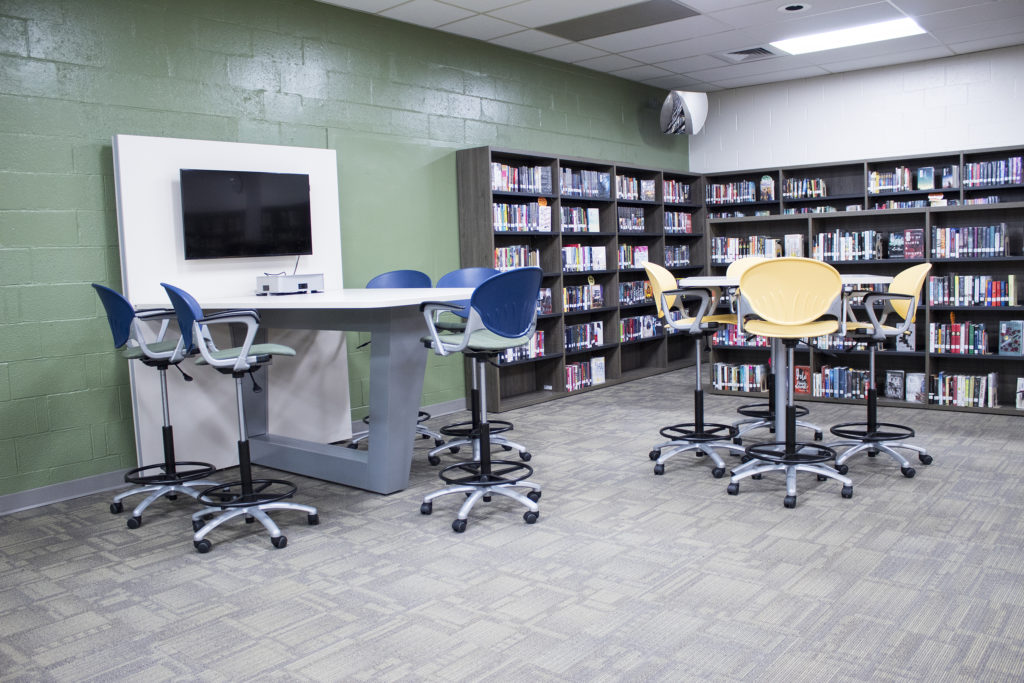 school library with collaborative media table book shelves stools education furniture office furniture and architectural interiors products